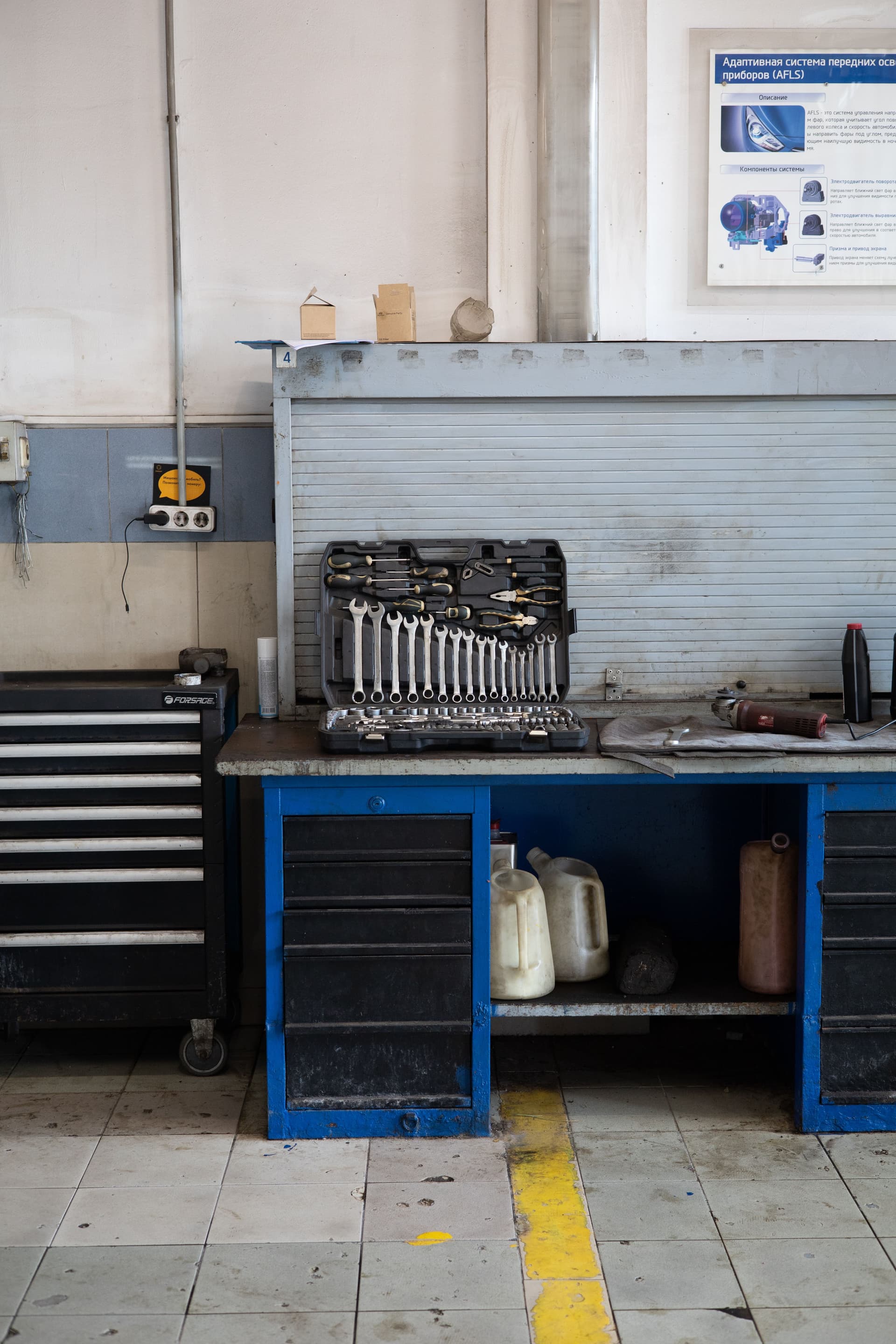 A set of mechanic tools laid out on top of a cabinet in a repair shop